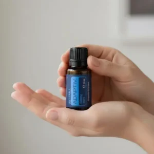 Dłonie trzymające Adaptiv doTERRA – aplikacja olejku
