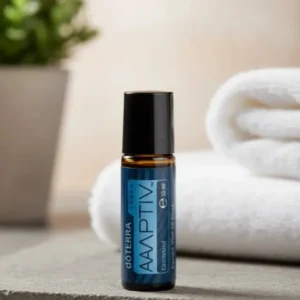 Adaptiv Touch doTERRA na kamiennej podstawce obok złożonych ręczników spa