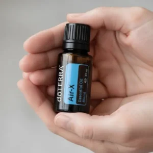 Dłonie trzymające Air-x doTERRA – aplikacja olejku