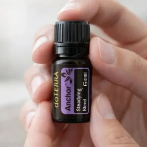 Dłonie trzymające Anchor doTERRA – aplikacja olejku