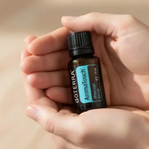 Dłonie trzymające Aromatouch doTERRA – aplikacja olejku