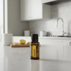 Olejek eteryczny Cytryna doTERRA na białym blacie kuchennym z cytryną w tle