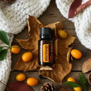Olejek eteryczny Dzika Pomarańcza doTERRA na jesiennych liściach z kumkwatami i szyszkami