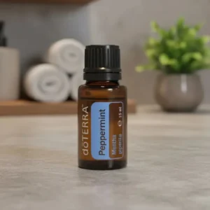 Olejek eteryczny Mięta Pieprzowa doTERRA na blacie łazienki z ręcznikami i rośliną