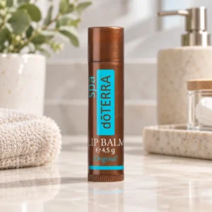 Balsam do ust doTERRA Original na blacie w łazience obok ręcznika i dozownika mydła