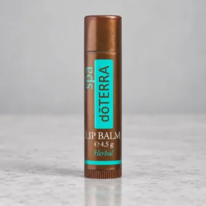 Sztyft balsamu do ust doTERRA SPA Herbal na szarym kamiennym blacie