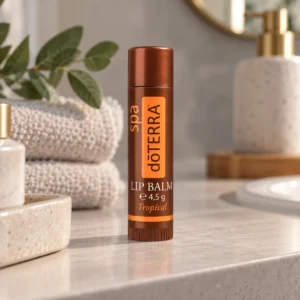 Balsam do ust doTERRA Tropical na blacie w łazience obok złożonych ręczników