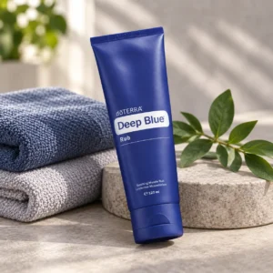 Balsam Deep Blue doTERRA na kamiennej podstawce obok złożonych ręczników spa