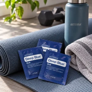 Saszetki Deep Blue Rub doTERRA na macie do ćwiczeń obok butelki i hantli