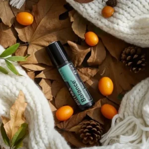 Balance Touch doTERRA na jesiennej dekoracji z liśćmi i szyszkami