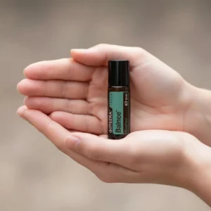 Dłonie trzymające Balance Touch doTERRA – aplikacja olejku
