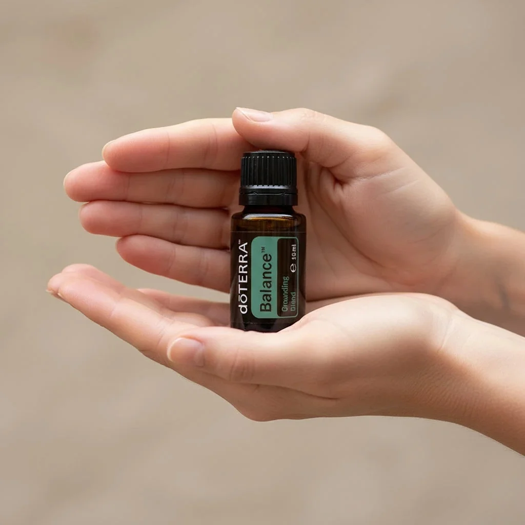 Dłonie trzymające Balance doTERRA – aplikacja olejku