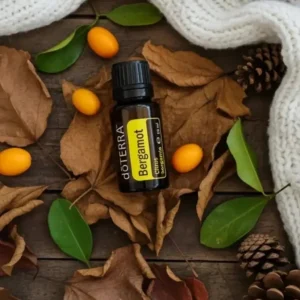 Bergamotka doTERRA na jesiennej dekoracji z liśćmi i szyszkami