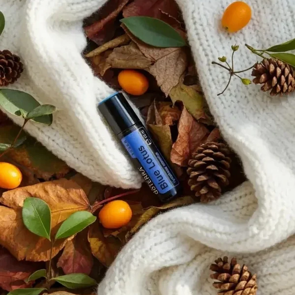 Blue Lotus Touch doTERRA na jesiennej dekoracji z liśćmi i szyszkami