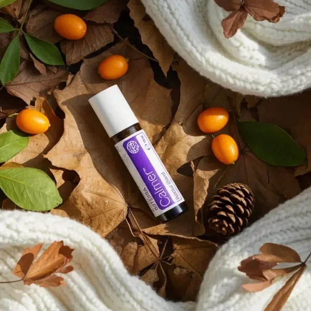 Calmer doTERRA na jesiennej dekoracji z liśćmi i szyszkami
