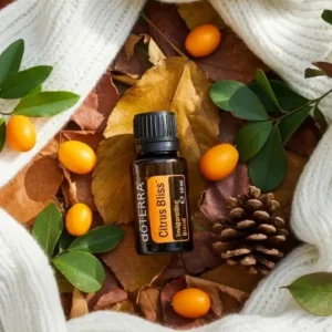 Citrus Bliss doTERRA na jesiennej dekoracji z liśćmi i szyszkami