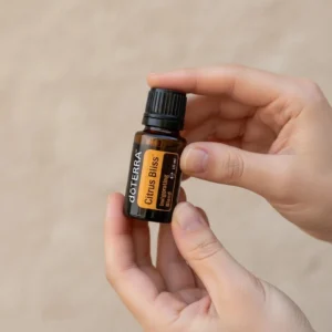 Dłonie trzymające Citrus Bliss doTERRA – aplikacja olejku