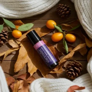 Clarycalm doTERRA na jesiennej dekoracji z liśćmi i szyszkami