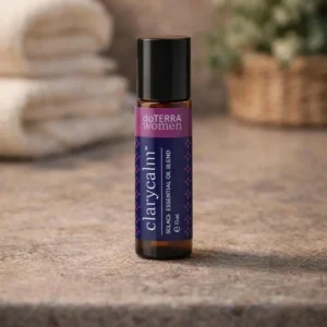Clarycalm doTERRA na kamiennej podstawce obok złożonych ręczników spa