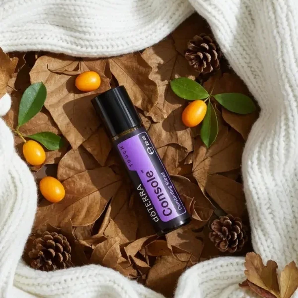 Console Touch doTERRA na jesiennej dekoracji z liśćmi i szyszkami