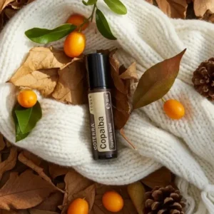 Copaiba Touch doTERRA na jesiennej dekoracji z liśćmi i szyszkami