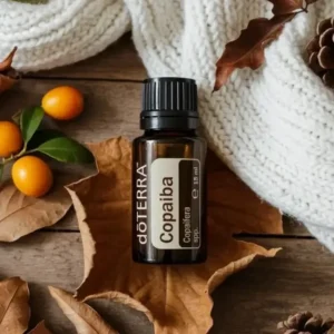 Copaiba doTERRA na jesiennej dekoracji z liśćmi i szyszkami