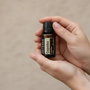 Dłonie trzymające Copaiba doTERRA – aplikacja olejku