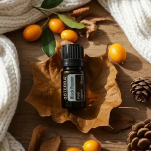 Czarny Pieprz doTERRA na jesiennej dekoracji z liśćmi i szyszkami