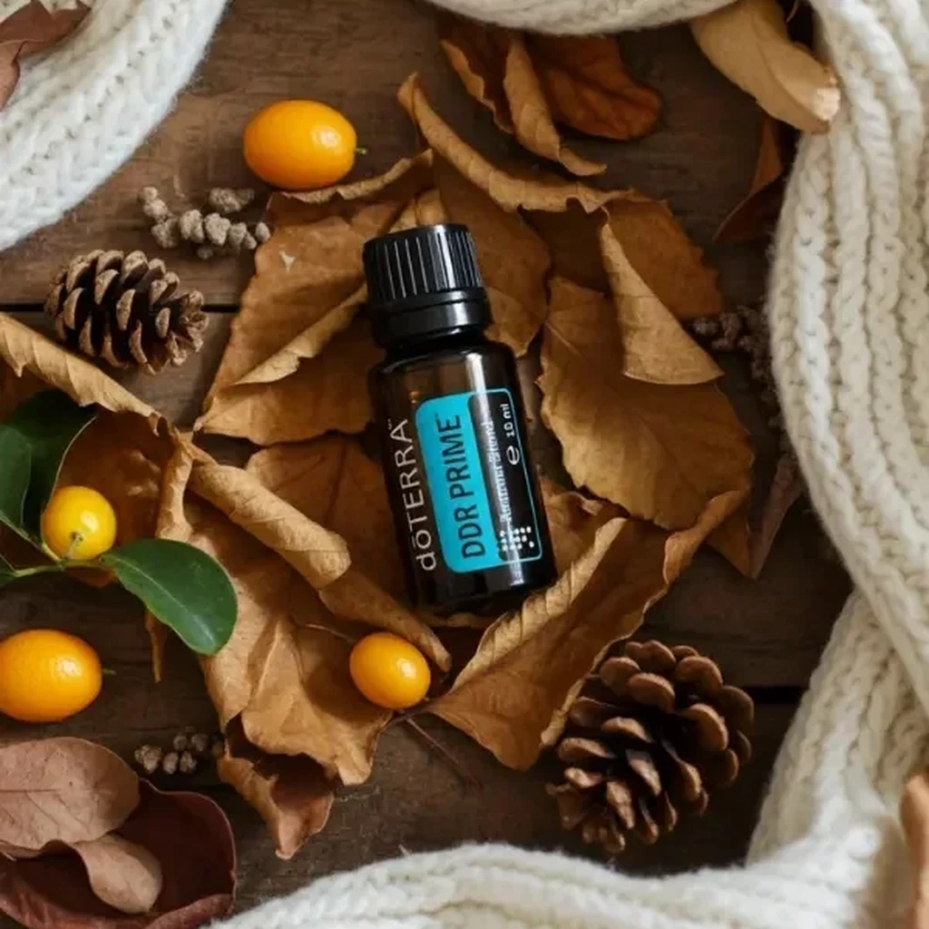 Ddr Prime doTERRA na jesiennej dekoracji z liśćmi i szyszkami