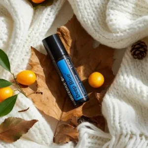 Deep Blue Roll-on doTERRA na jesiennej dekoracji z liśćmi i szyszkami