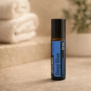 Deep Blue Touch doTERRA na kamiennej podstawce obok złożonych ręczników spa