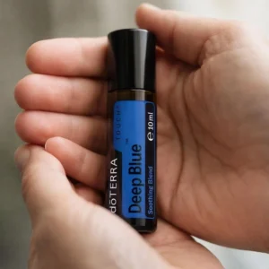 Dłonie trzymające Deep Blue Touch doTERRA – aplikacja olejku