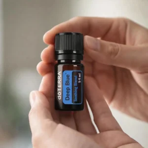 Dłonie trzymające Deep Blue doTERRA – aplikacja olejku