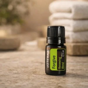 Forgive doTERRA na kamiennej podstawce obok złożonych ręczników spa