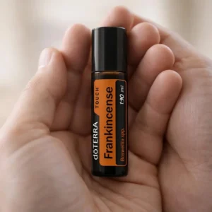 Dłonie trzymające Frankincense Touch doTERRA – aplikacja olejku