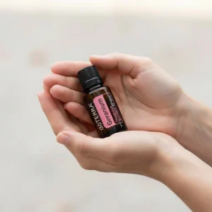 Dłonie trzymające Geranium doTERRA – aplikacja olejku
