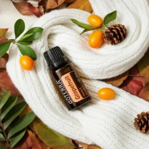 Grejpfrut doTERRA na jesiennej dekoracji z liśćmi i szyszkami