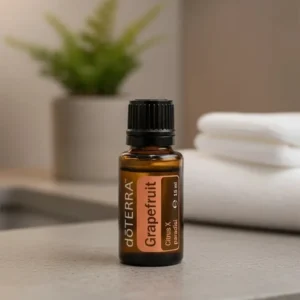Grejpfrut doTERRA na kamiennej podstawce obok złożonych ręczników spa