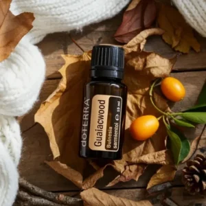 Gwajakowiec doTERRA na jesiennej dekoracji z liśćmi i szyszkami