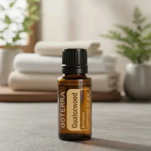 Gwajakowiec doTERRA na kamiennej podstawce obok złożonych ręczników spa
