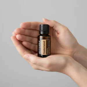 Dłonie trzymające Gwajakowiec doTERRA – aplikacja olejku