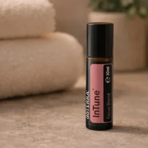 Intune doTERRA na kamiennej podstawce obok złożonych ręczników spa