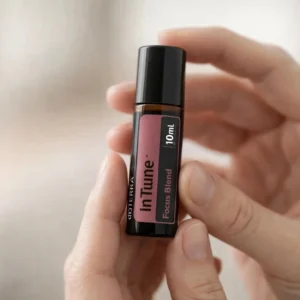 Dłonie trzymające Intune doTERRA – aplikacja olejku