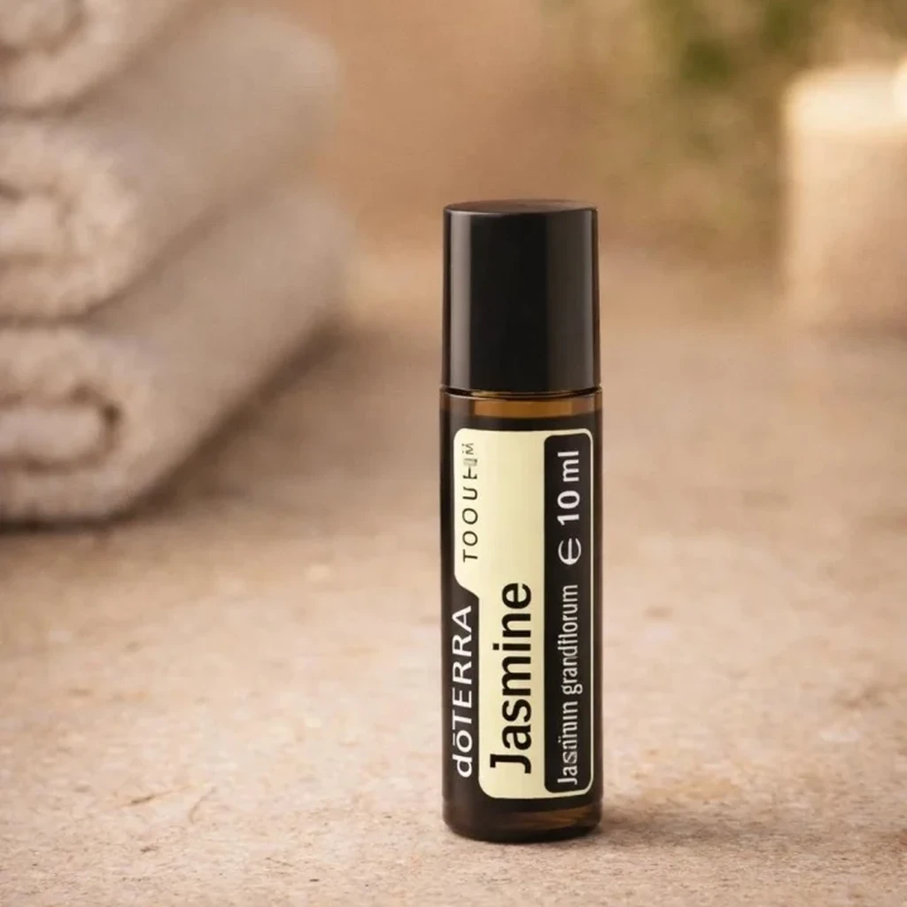 Jasmine Touch doTERRA na kamiennej podstawce obok złożonych ręczników spa