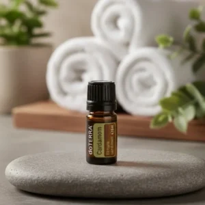 Kardamon doTERRA na kamiennej podstawce obok złożonych ręczników spa