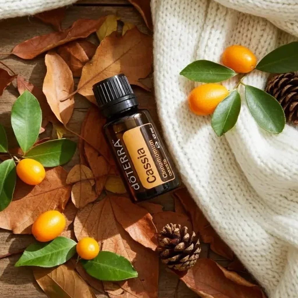 Kasja doTERRA na jesiennej dekoracji z liśćmi i szyszkami