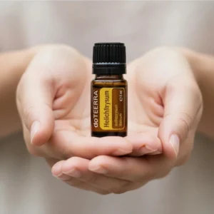 Dłonie trzymające Kocanka Włoska doTERRA – aplikacja olejku