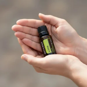 Dłonie trzymające Limonka doTERRA – aplikacja olejku