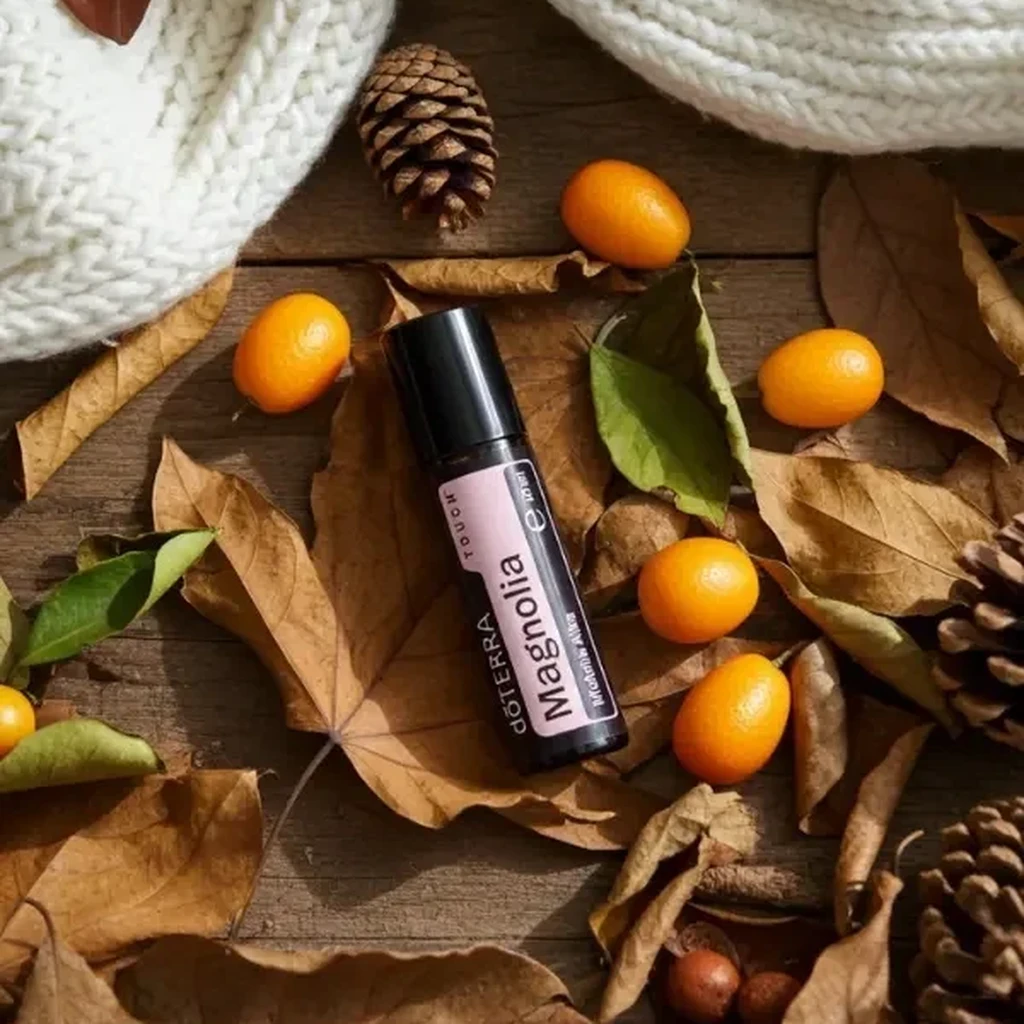 Magnolia Touch doTERRA na jesiennej dekoracji z liśćmi i szyszkami