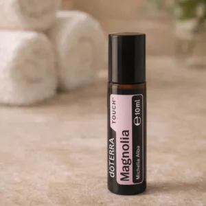 Magnolia Touch doTERRA na kamiennej podstawce obok złożonych ręczników spa